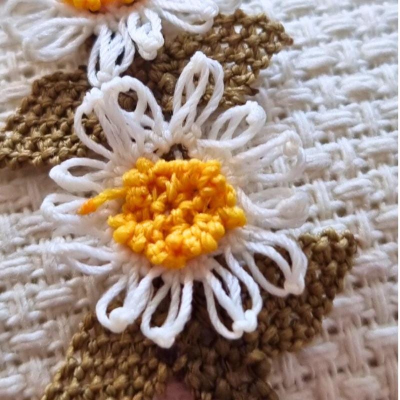 A handmade bracelet with three white daisy flowers made from needle lace, featuring yellow centers and green leaves, set on an olive green adjustable band. Made using artificial silk thread with traditional Turkish Oya technique.